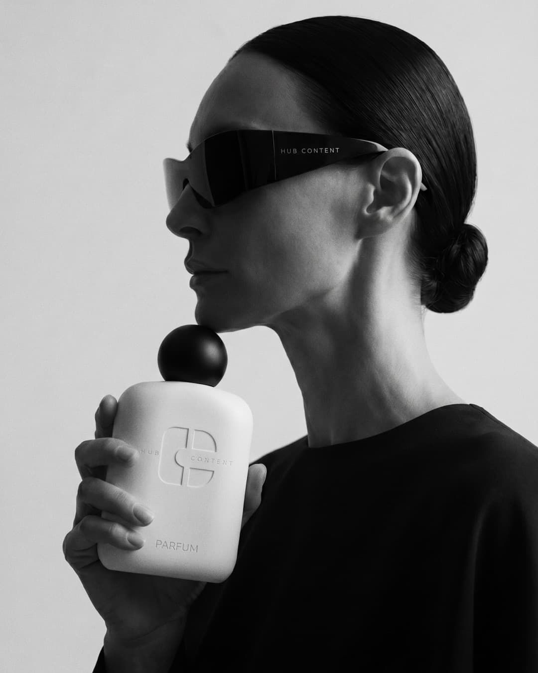 Campaign shot: model holding the brand perfume bottle